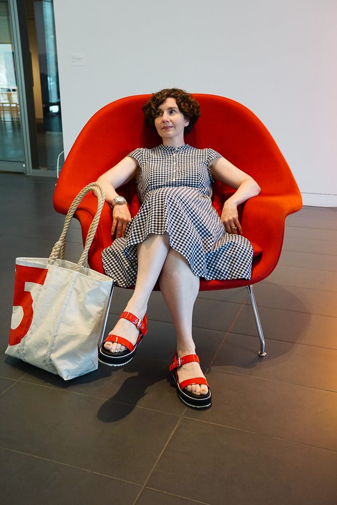 The Directrice finds another red chair for power-slacking